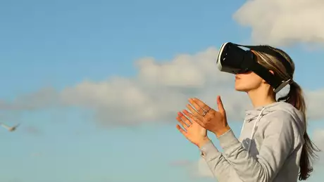 Bild på en kvinna som simulerar med VR-glasögon. Källa: Pexels 